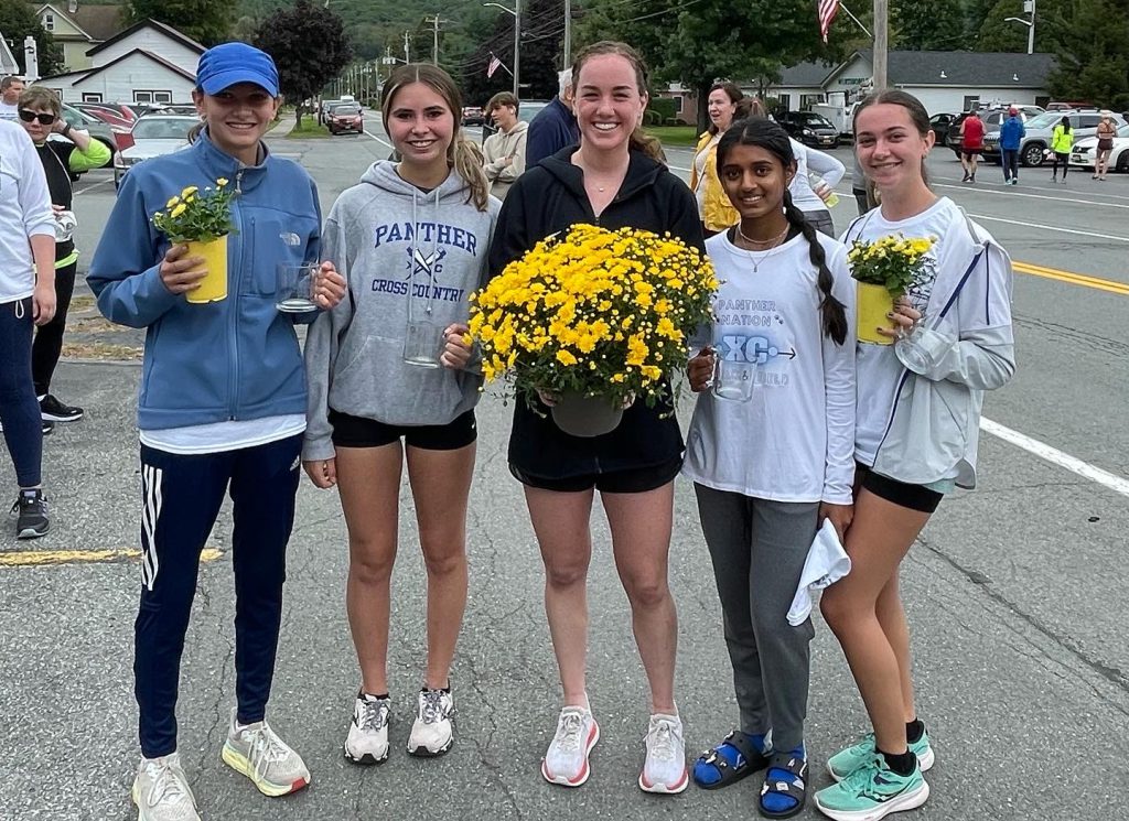 a group of female runners standing by a finish line