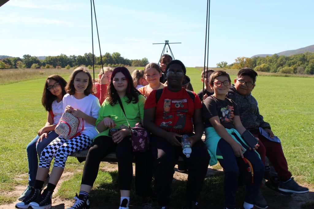 a group of students are seated on a swing 