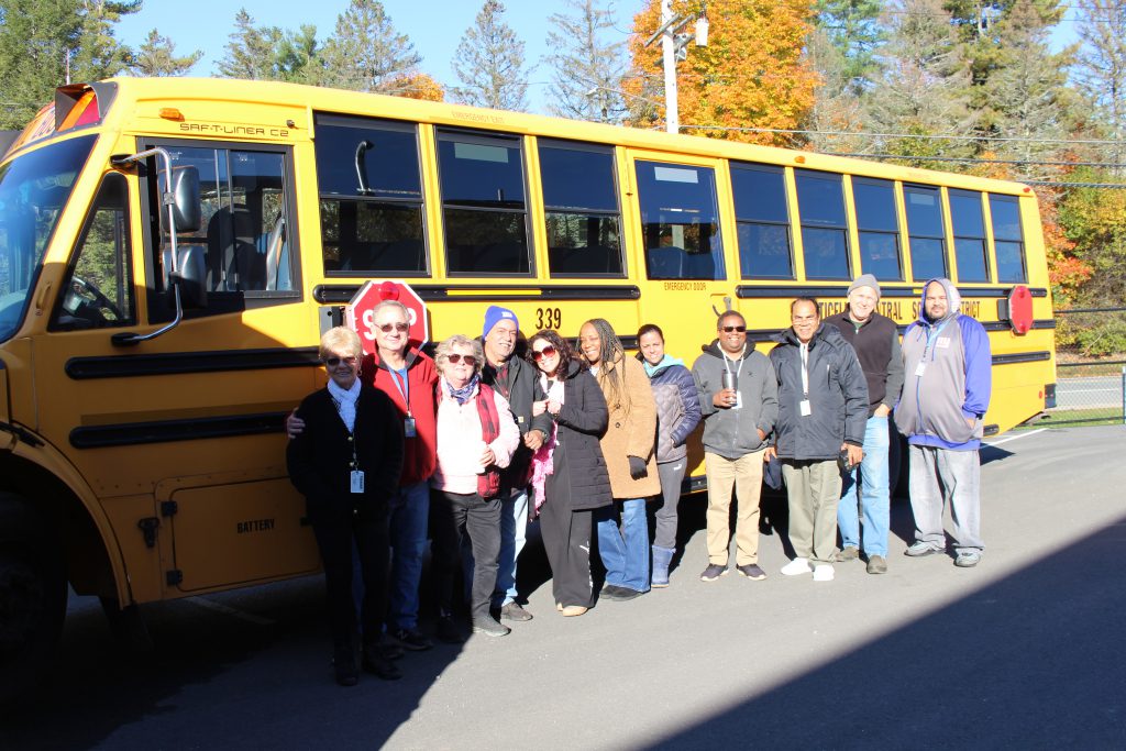 a group of bus drivers is standing before a bus