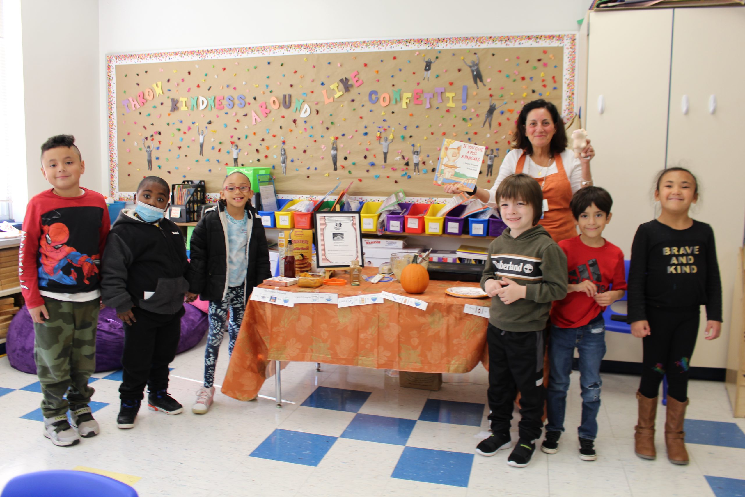 a group of students are posing around a table with pancakes