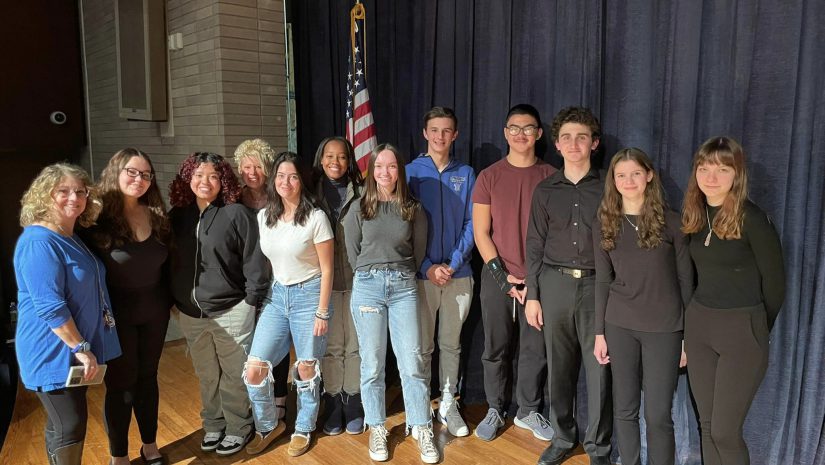 a group of students are standing on a stage and posing.