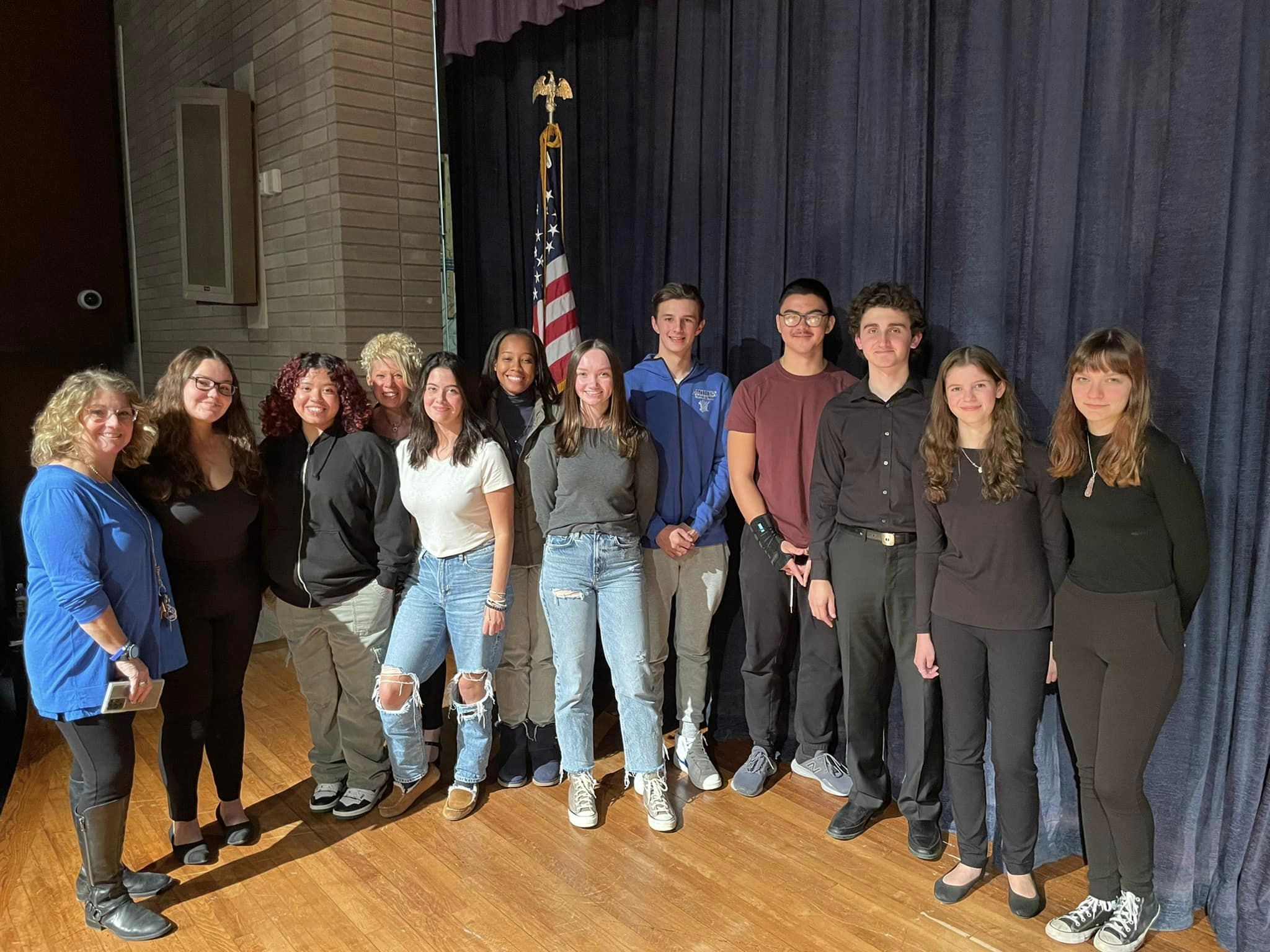 a group of students are standing on a stage and posing.