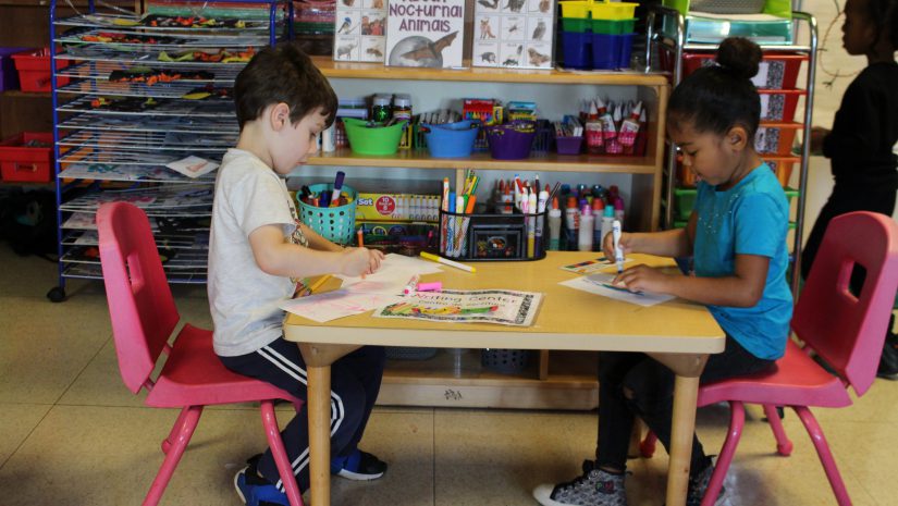 two students are seated at a desk