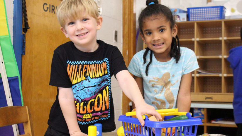 two young students, a boy and a girl, are playing with blocks