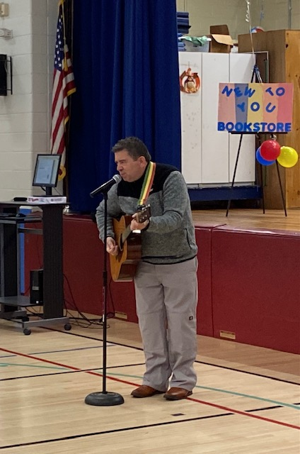 a man is playing a guitar in a gymnasium 