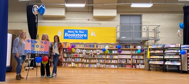 three women are standing in front of a large bookshelf filled with books 