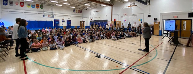 a large group of students are seated in a gymnasium for an assembly
