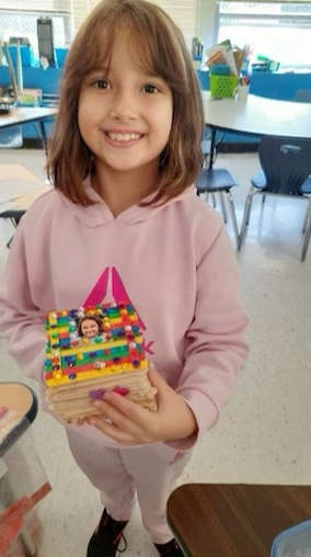 A young girl is holding a keepsake box that she made