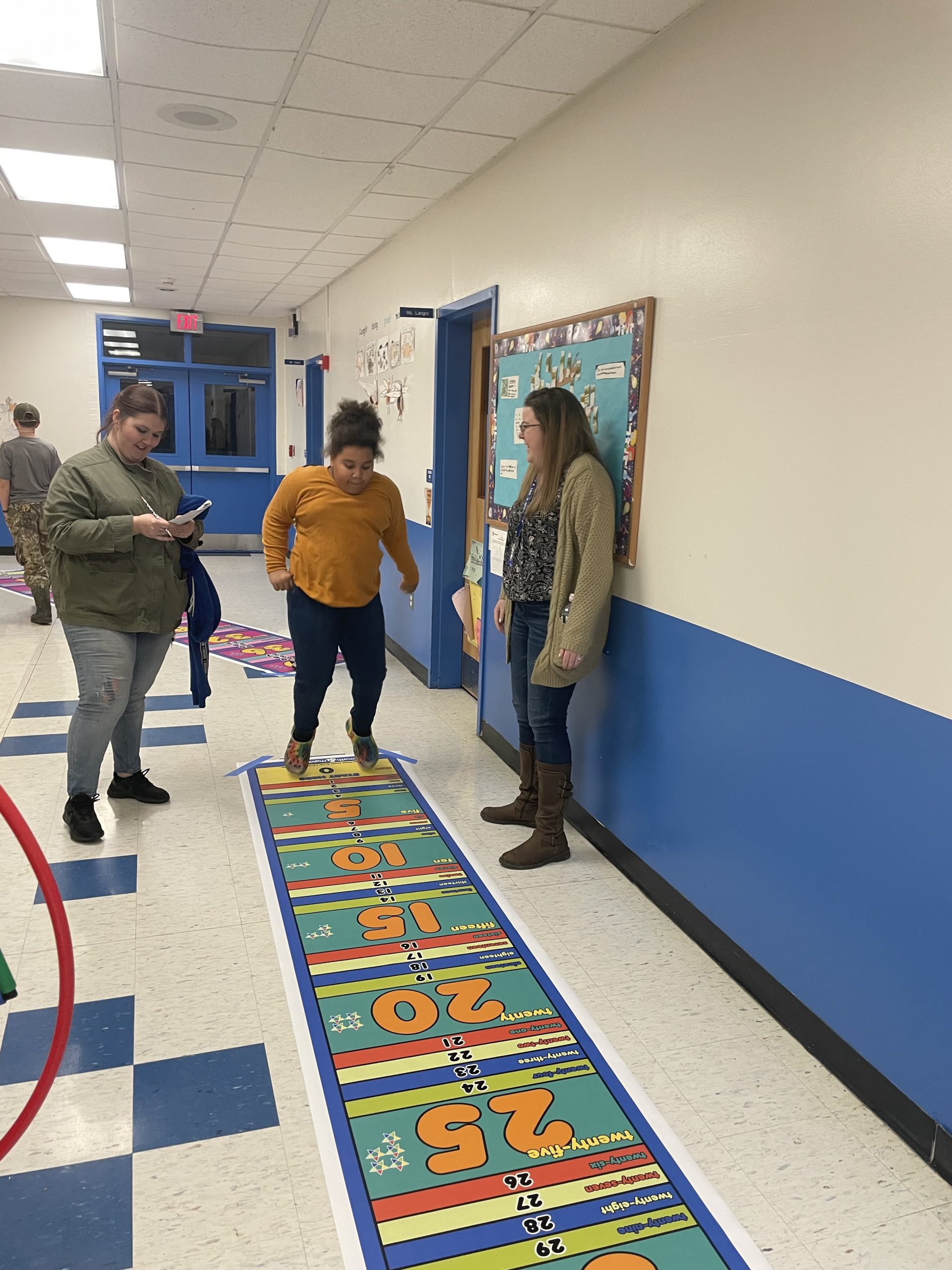 a girl is jumping on a math activity mat