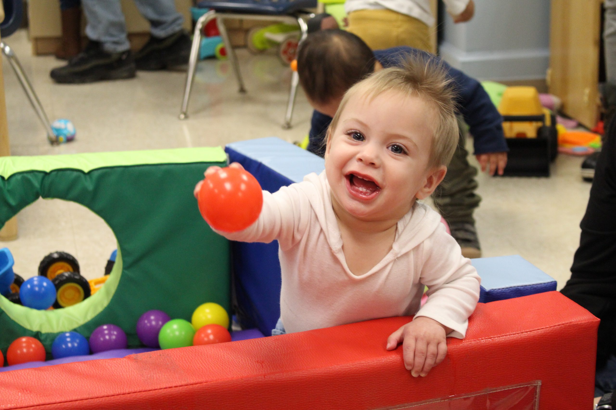 a young girl plays in a ball pit. 