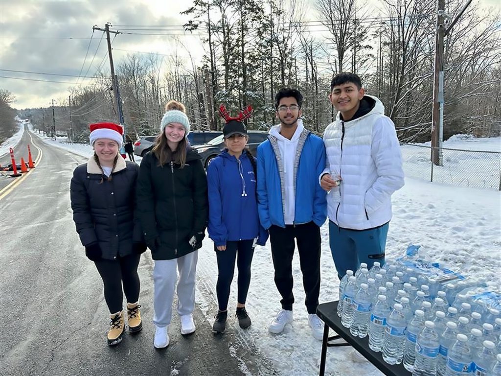 Students standing together outside to hand out bottles of water.