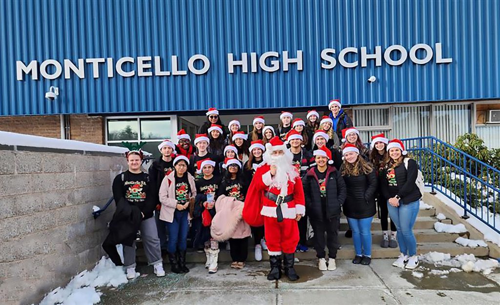 Santa and MHS students standing outside the front of the school.
