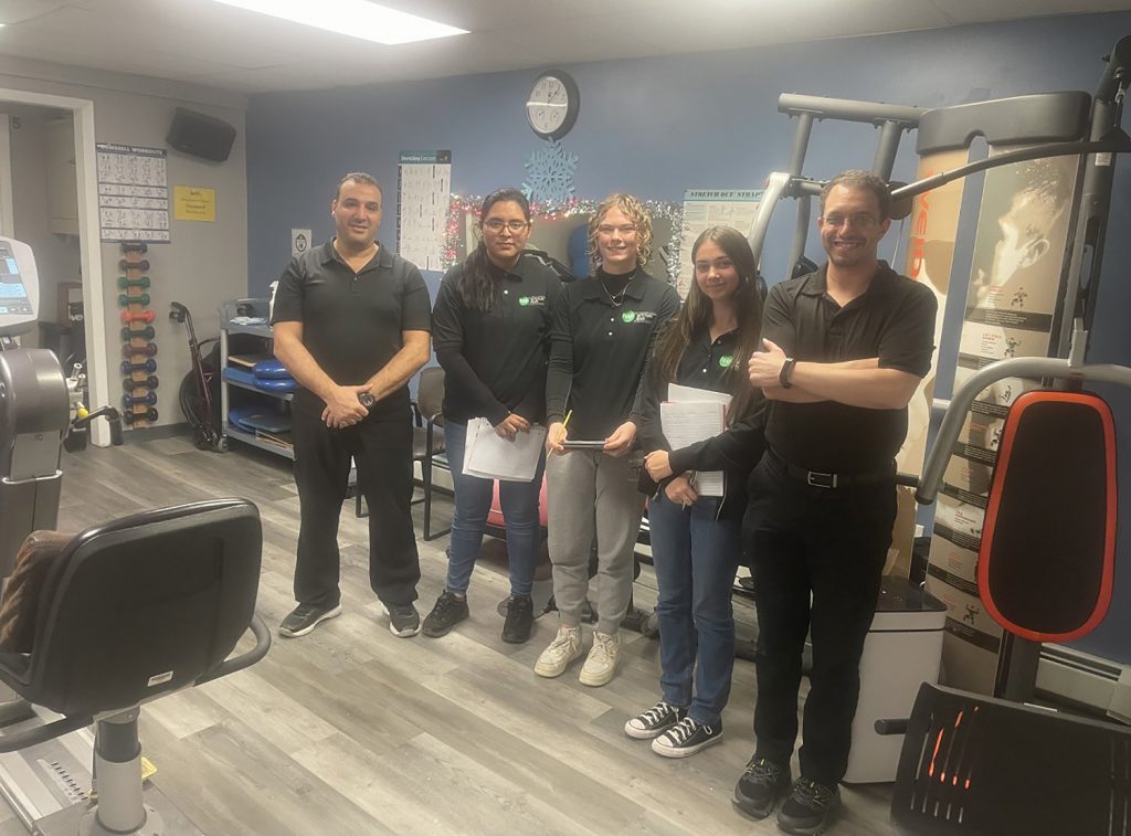 Students and staff at Mountain Physical Therapy standing for a photo together.