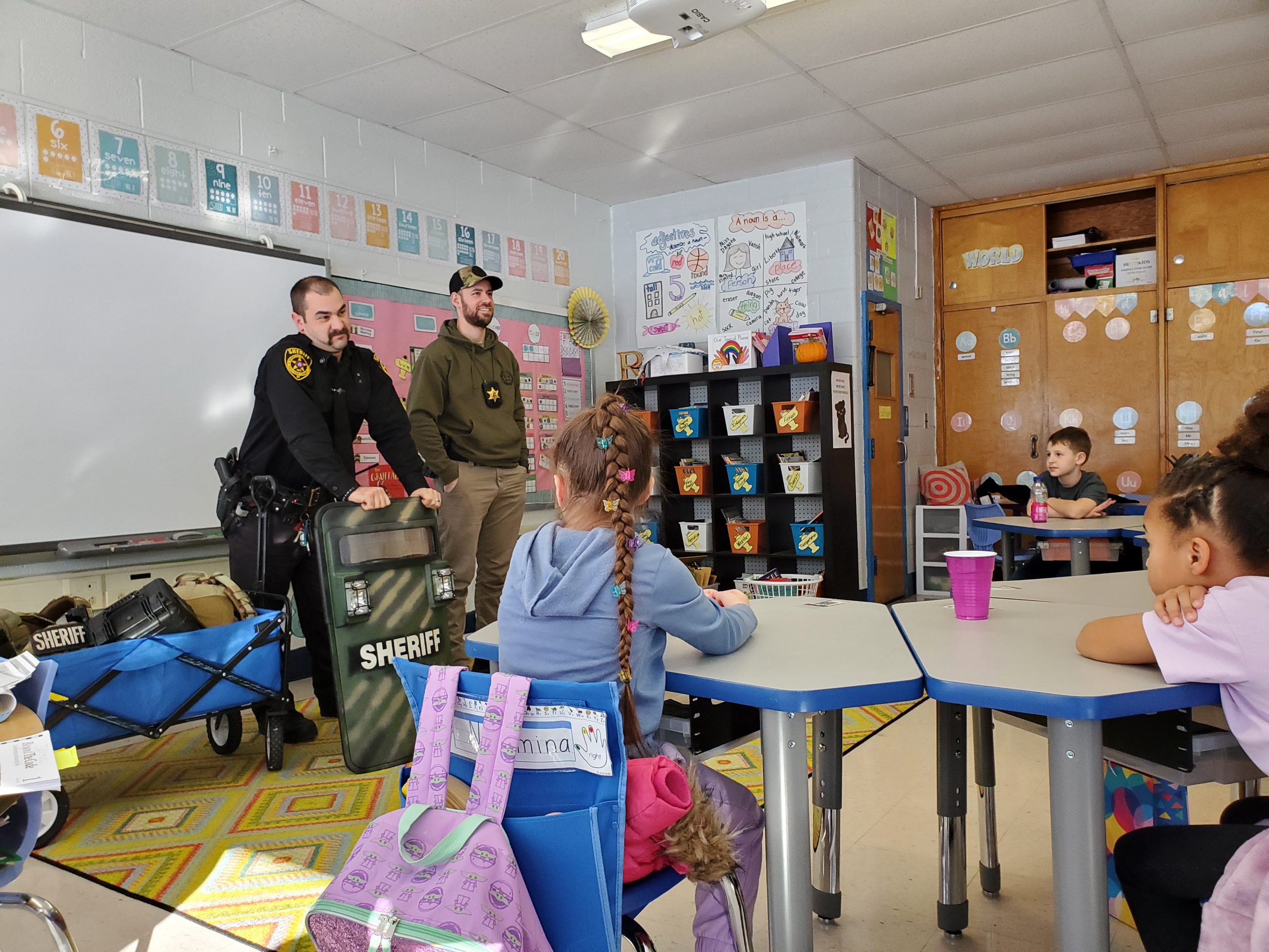 two officers are standing in front of a classroom 