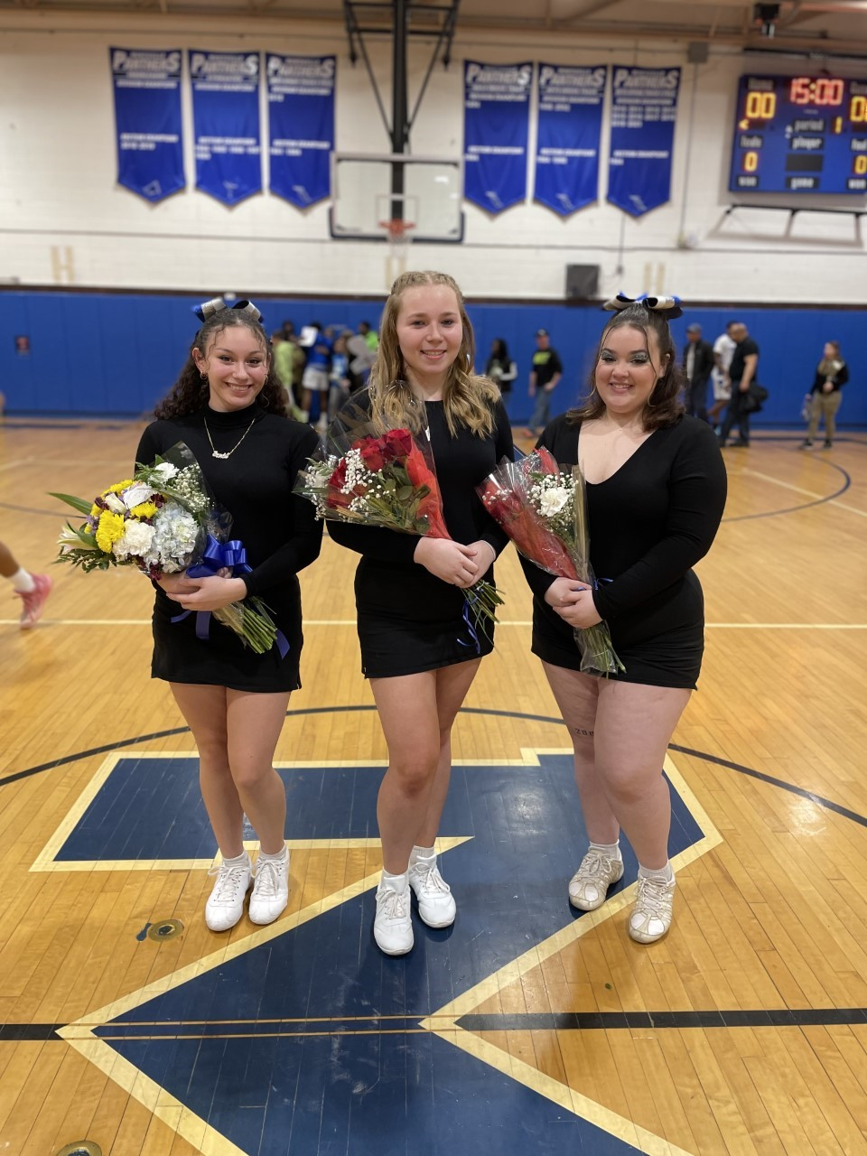 the senior cheerleaders pose on the court 