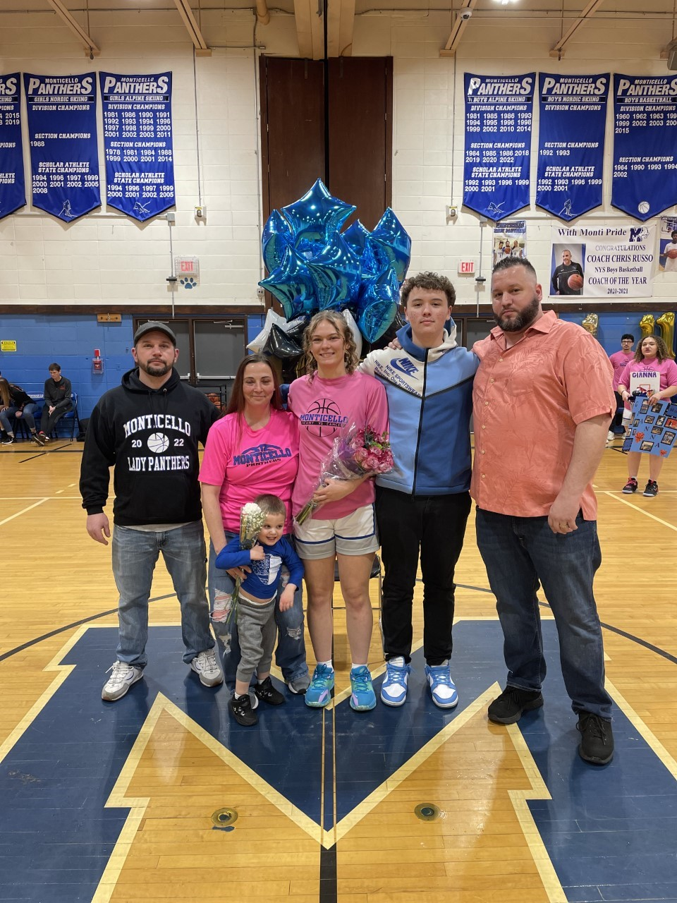 senior athletes pose with their family