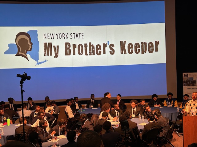 a room filled with young men at tables