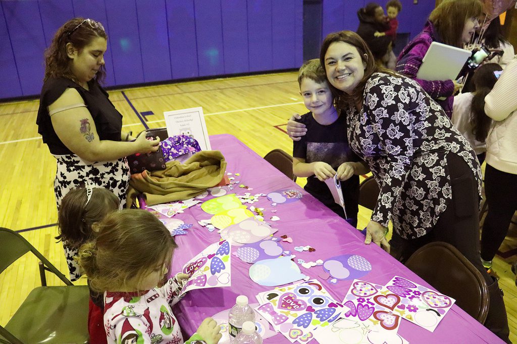 Families doing crafts at a table.