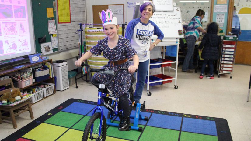 a student is pedaling on a bike that has a blender attached to it