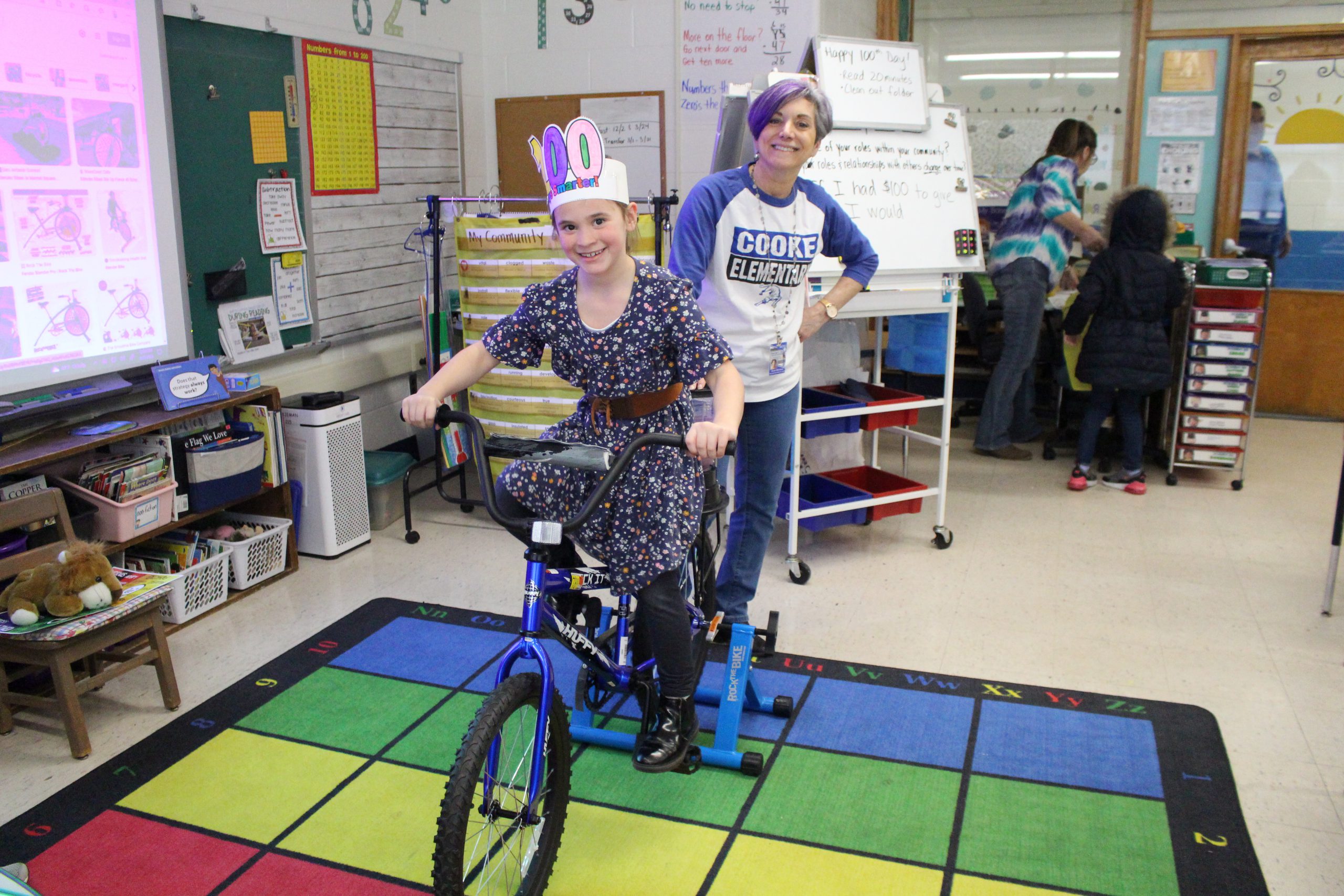 a student is pedaling on a bike that has a blender attached to it