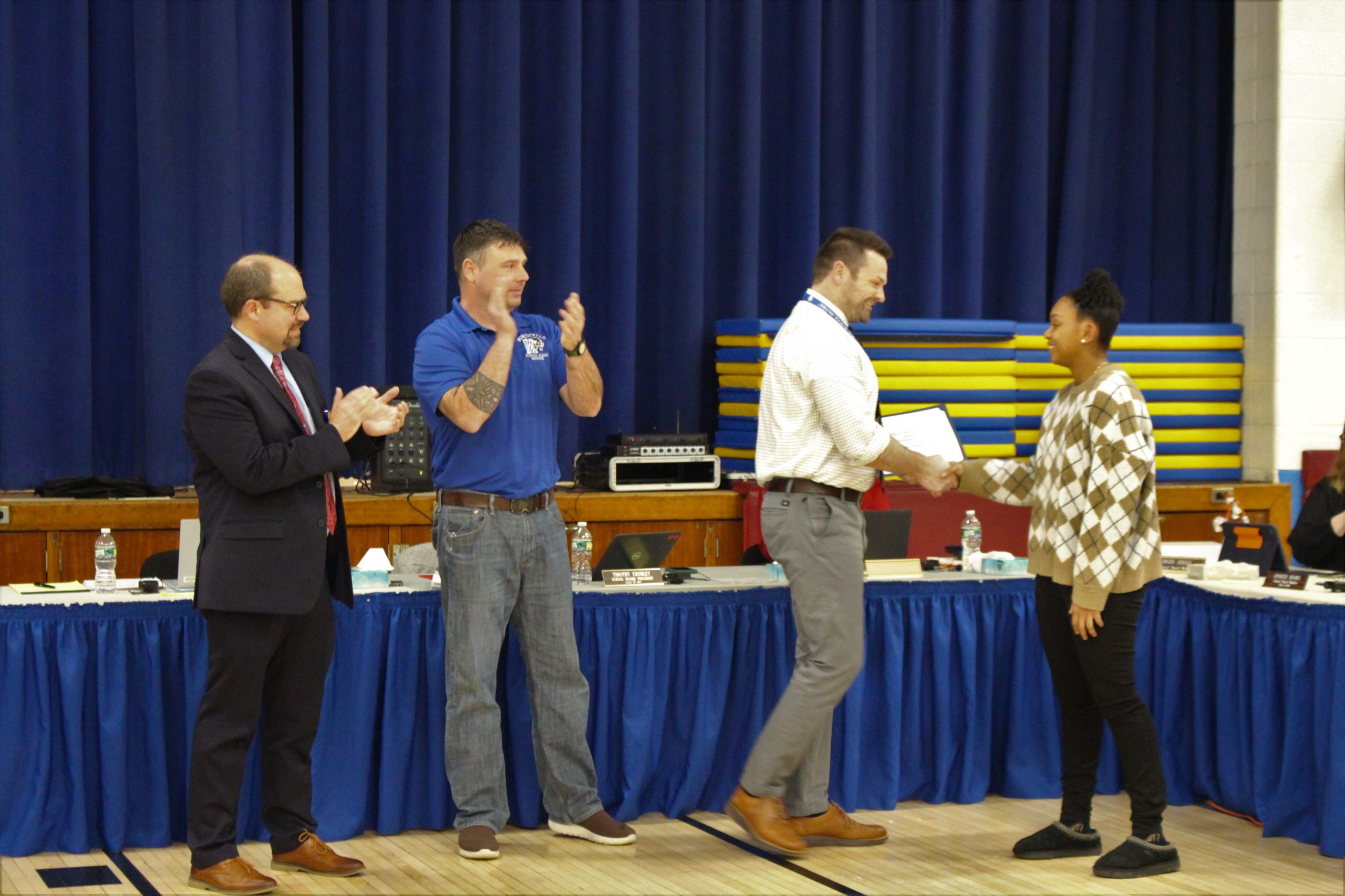 MCSD Director of Athletics Ryan Jasper presents Aaliyah Mota with a Board Award, as Board President Tim Crumley and Superintendent Matt Evans looks on. 