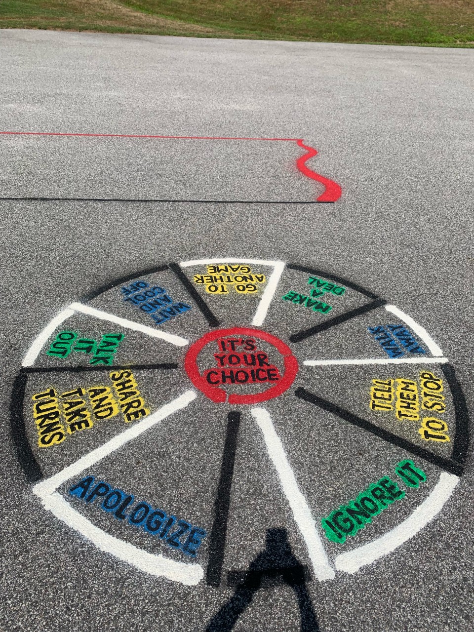 a circle is spray painted onto the blacktop. It lists different stratgies to settle disputes: apologize, walk away, talk it out, ignore it.  