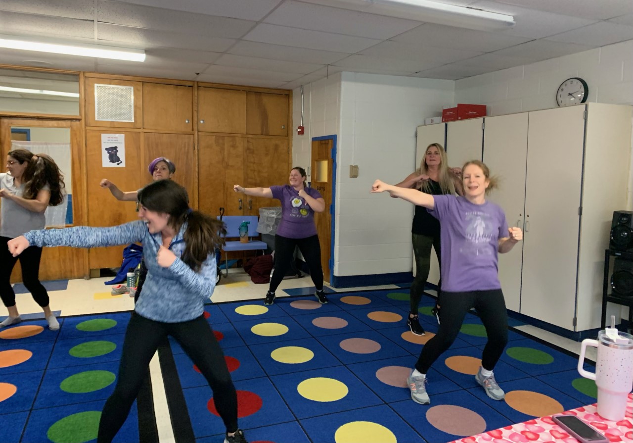 a group of adults are participating in an exercise class. 