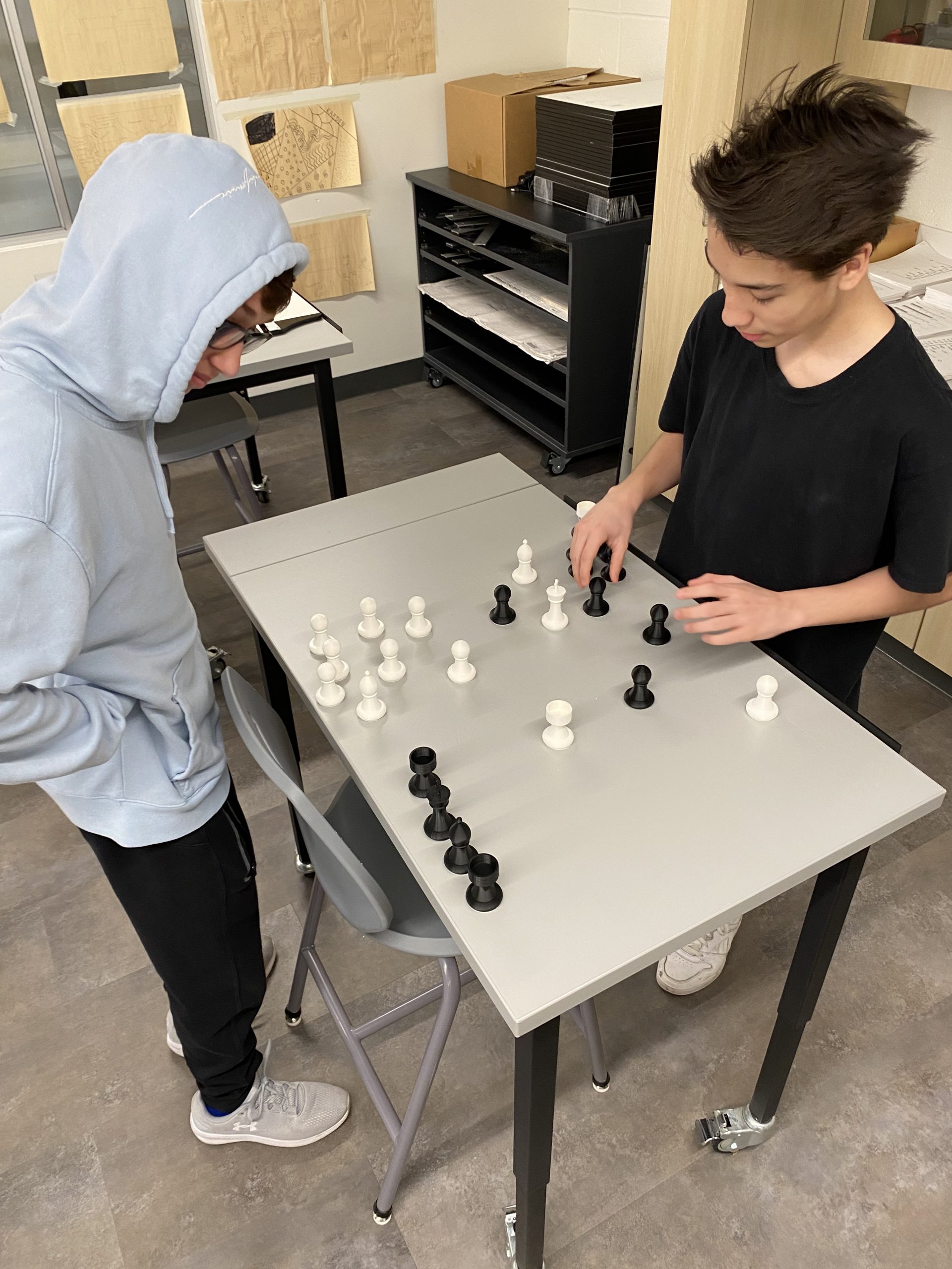 Students point out the chess pieces they created