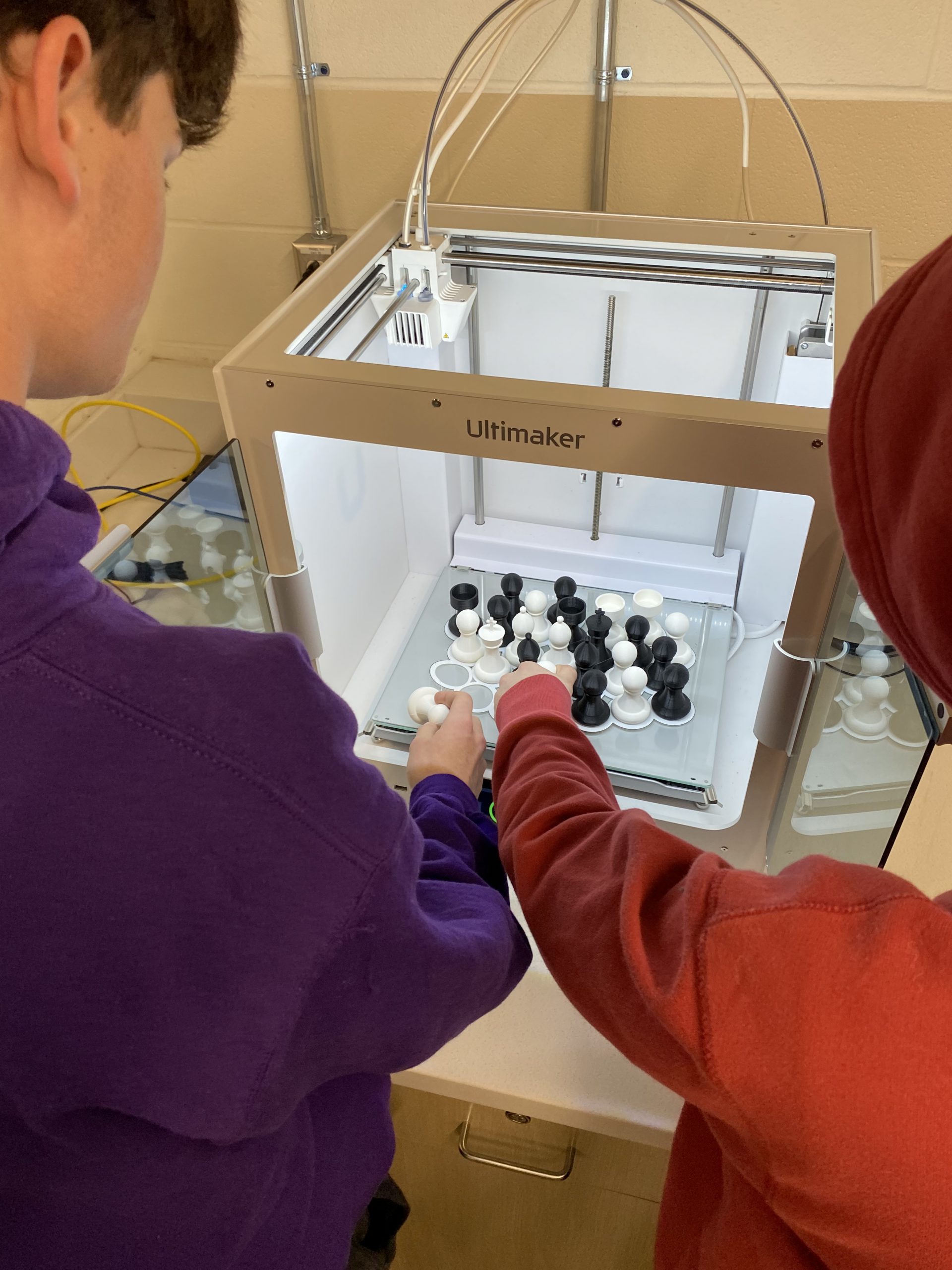 Students point out the chess pieces they created