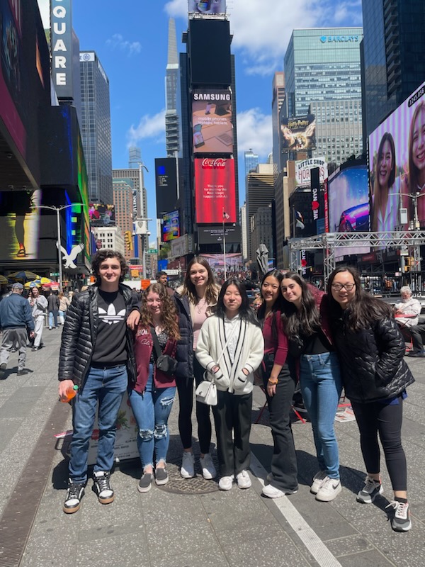 a group of students is posing in Times Square 