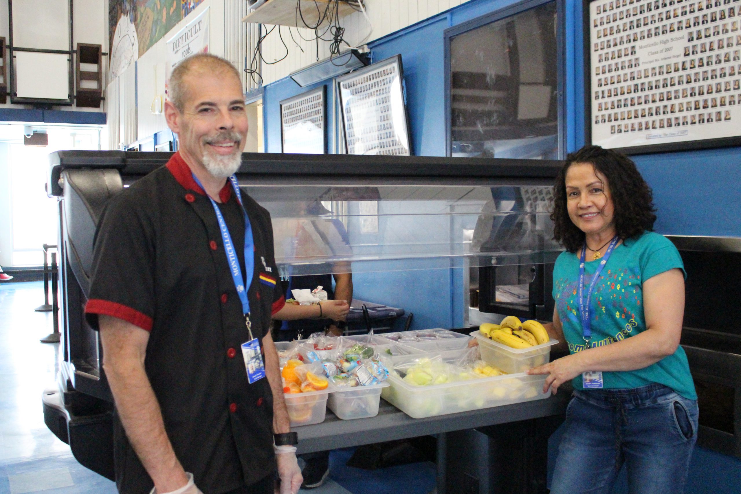 Mr. Thurston and a female food service worker pose in front of the salad bar