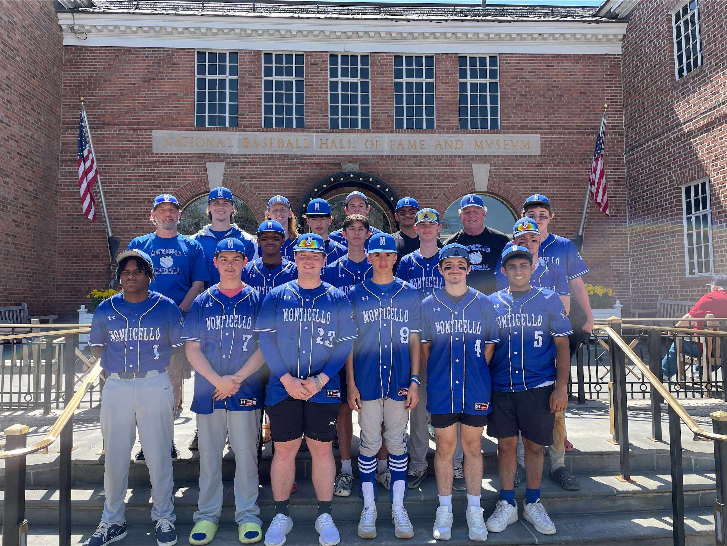 the baseball team poses on the steps of the hall of fame