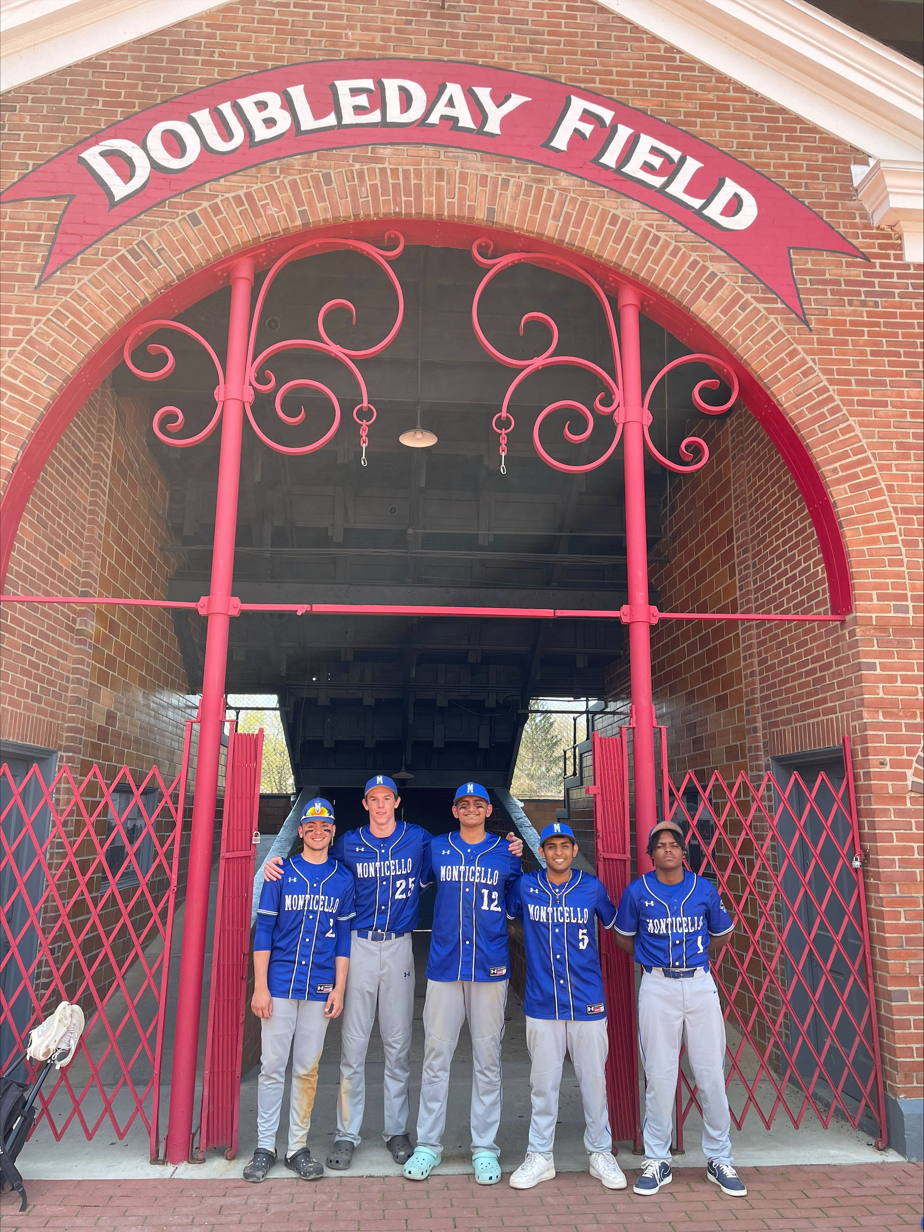 the baseball team is posing in front of the sign that says Doubleday Field 