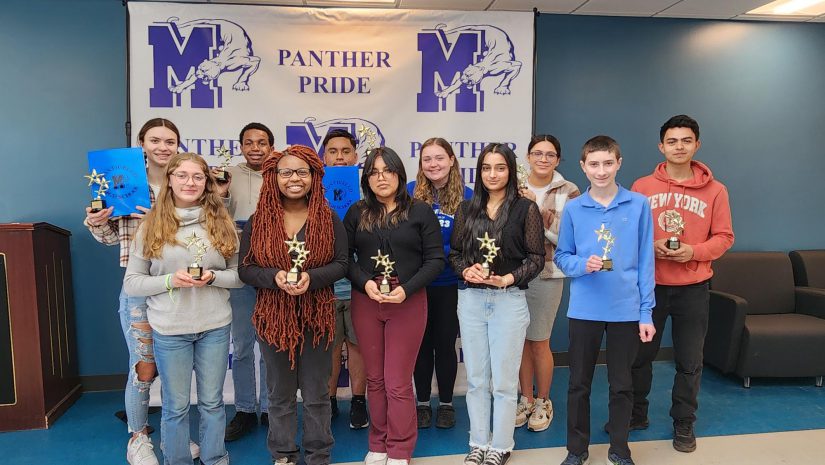 a group of students are standing with their awards in hand.