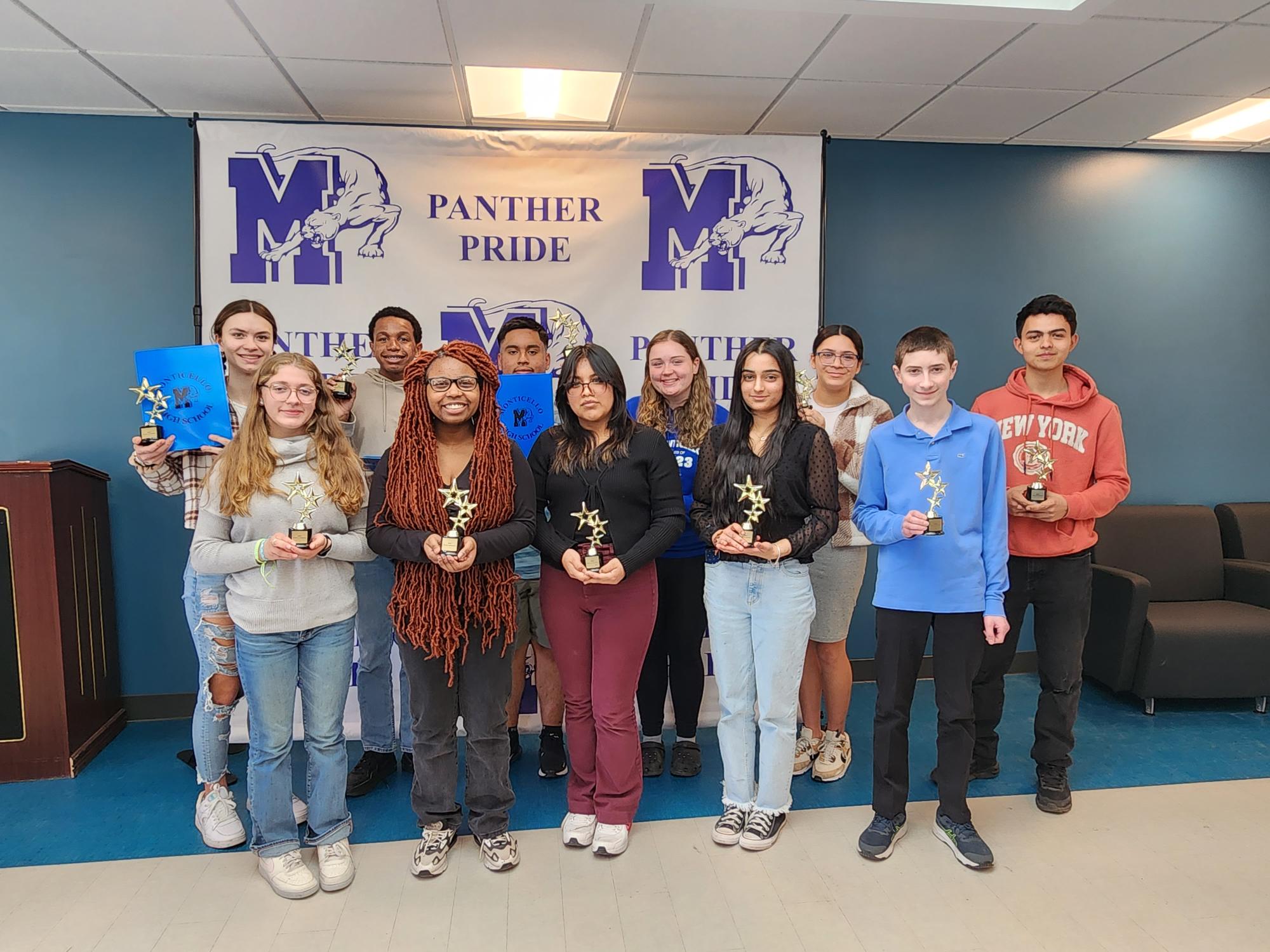 a group of students are standing with their awards in hand. 