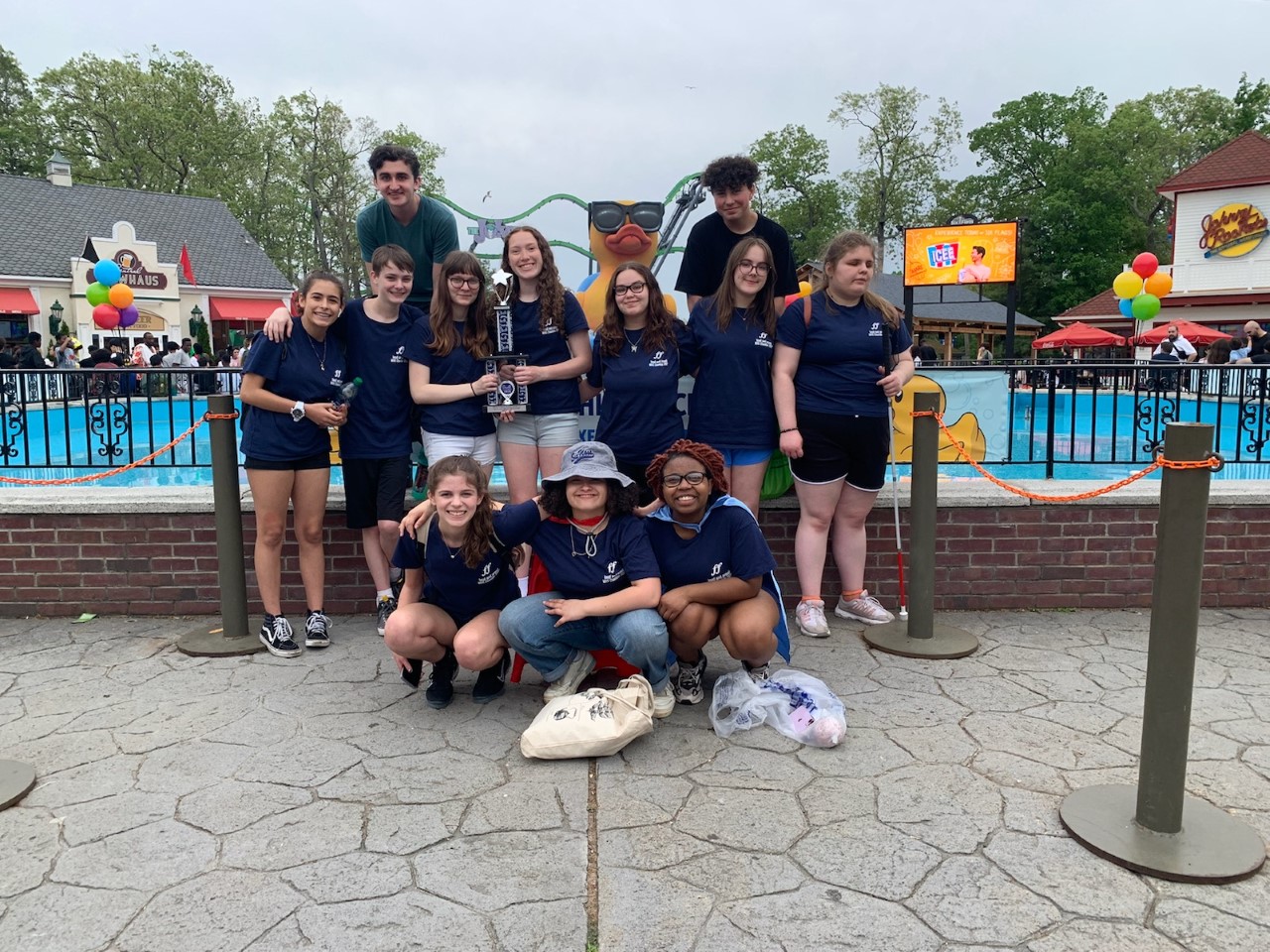 the chamber singers pose in front of the six flag amusement park 