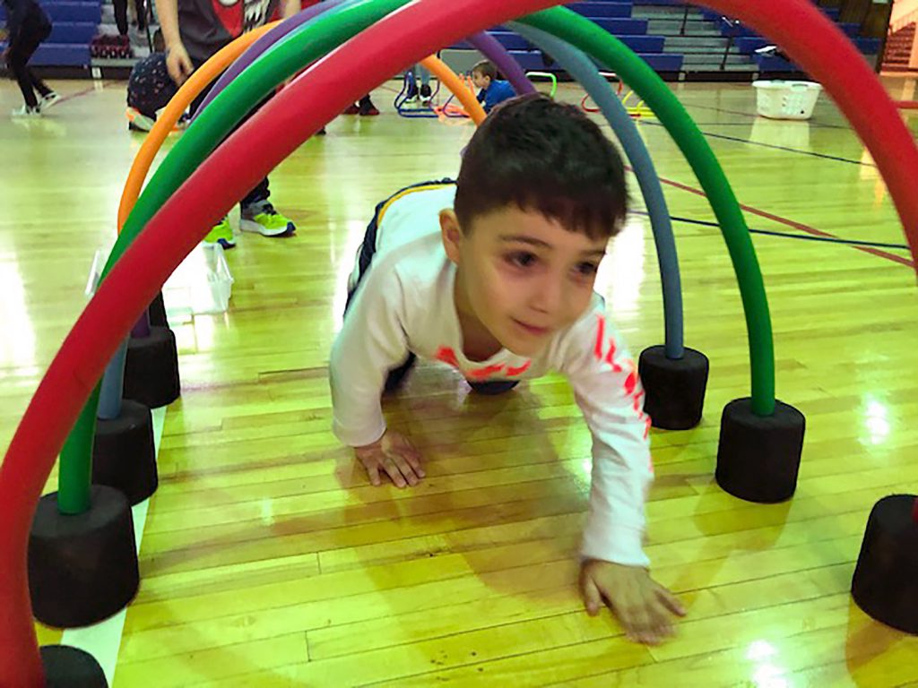 Student crawling through an obstacle.
