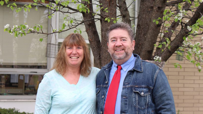 Ann Marie Kurthy and Bill Frandino are smiling next to a tree and posing