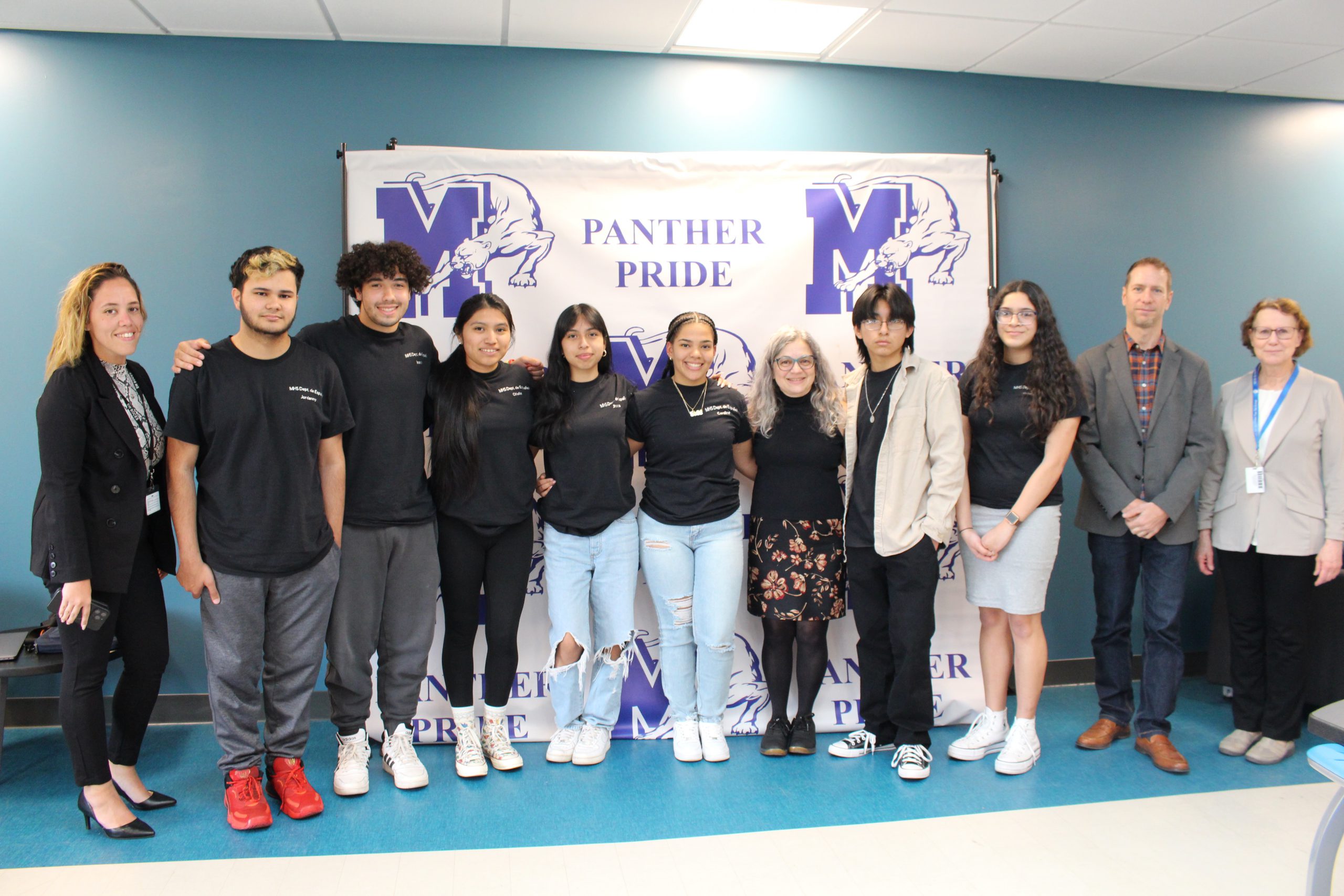 a group of students is posing in front of a backdrop 