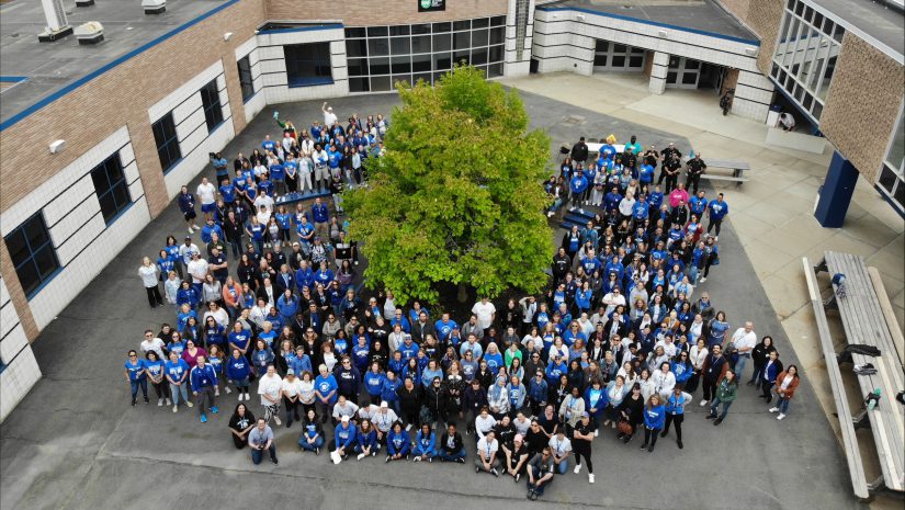 a group of people all wearing blue tshirts taken from a drone