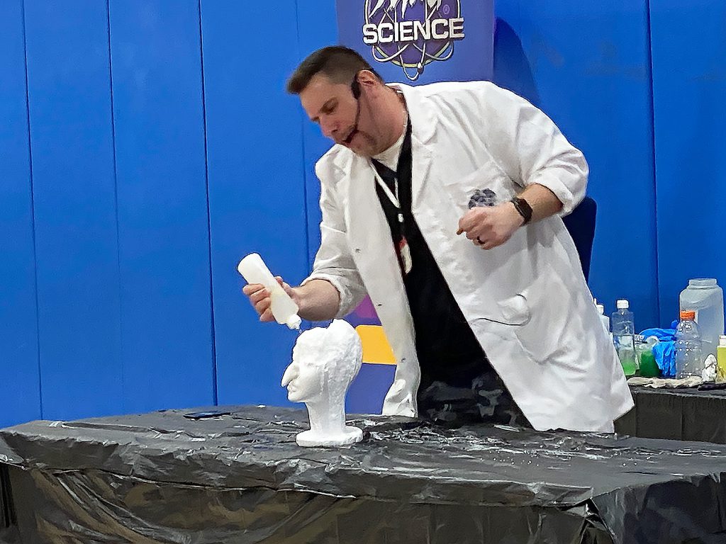 Scientist pouring water on statue.