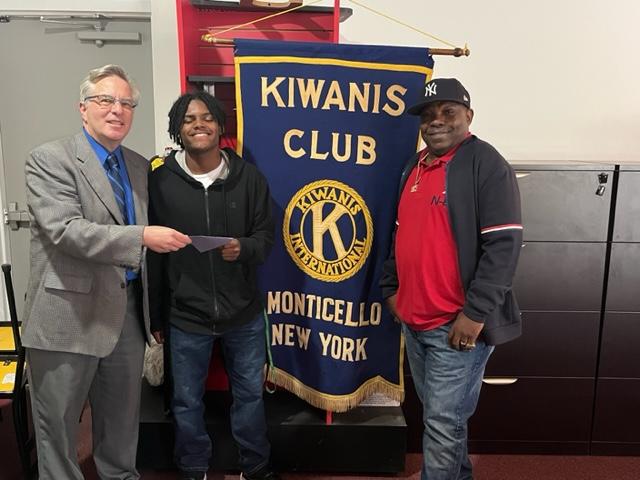 a scholarship recipient is posing with a kiwanis club member 