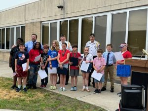 the seven students who received honorable mention pose with the veterans