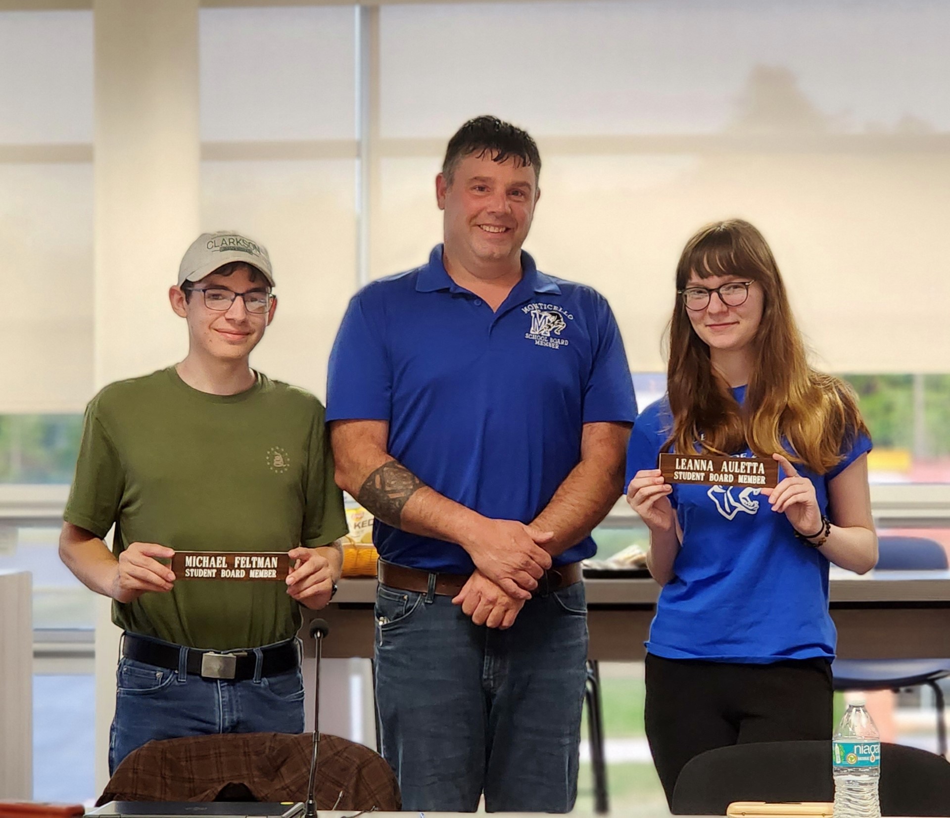 Michael Feltman and Leana Auletta are posing with Board President Tim Crumley