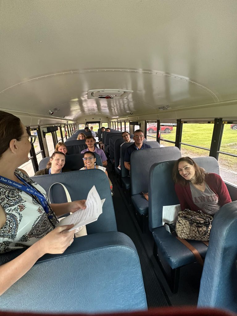 a group of teachers is sitting on a school bus