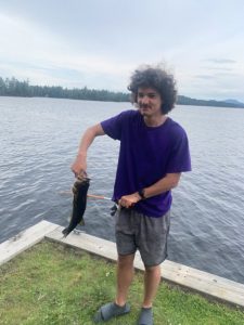 a student is holding a fish he caught