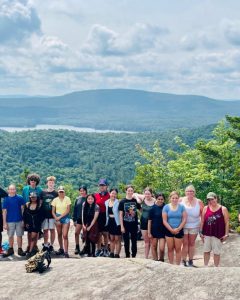 students pose on top of a mountain 