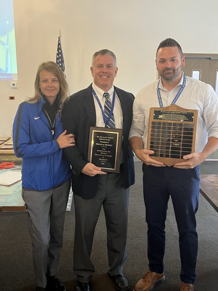 Doug Murphy is holding a plaque and posing with Ryan Jasper 