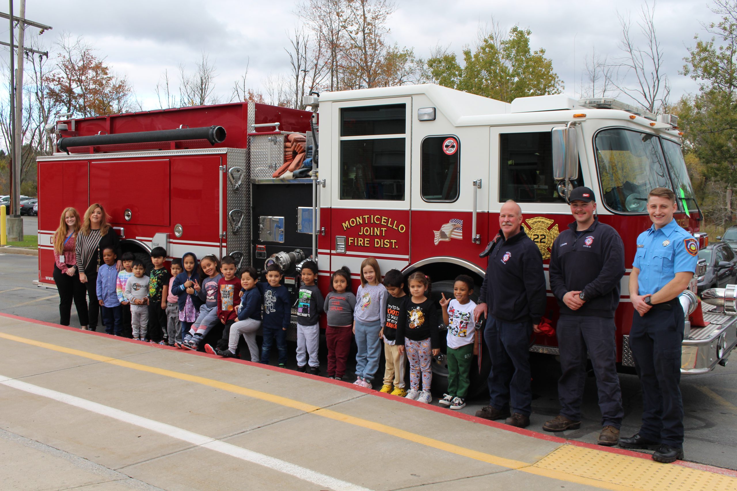 a group of young students is posing by a fire truck 