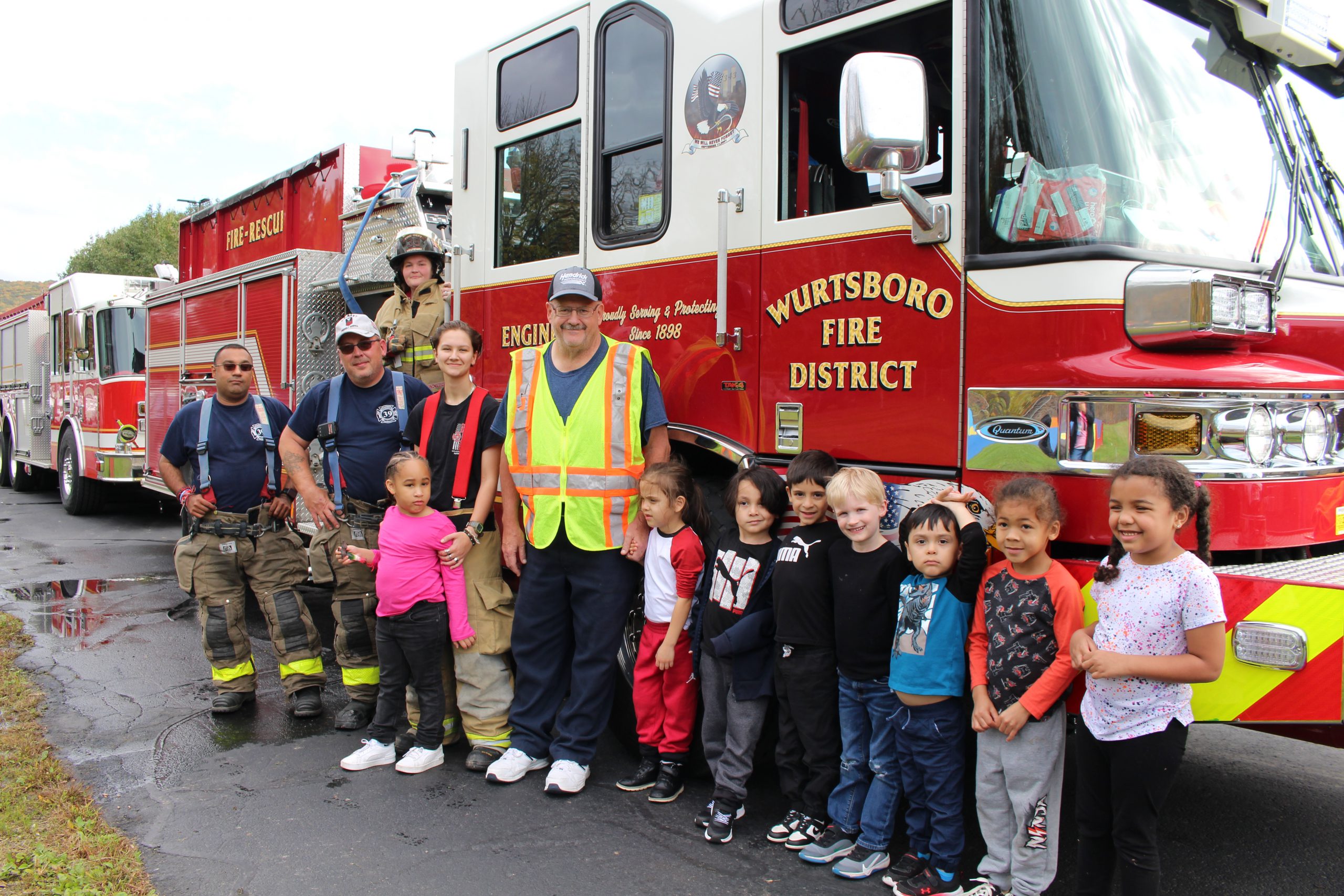 firefighters and students are posing next to a truck